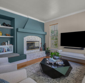 Transitional family room by Raashi Design with custom built-in shelving, marble mosaic fireplace with mantel, blue accent wall, neutral sofa and chairs, and geometric shaped wood coffee table.